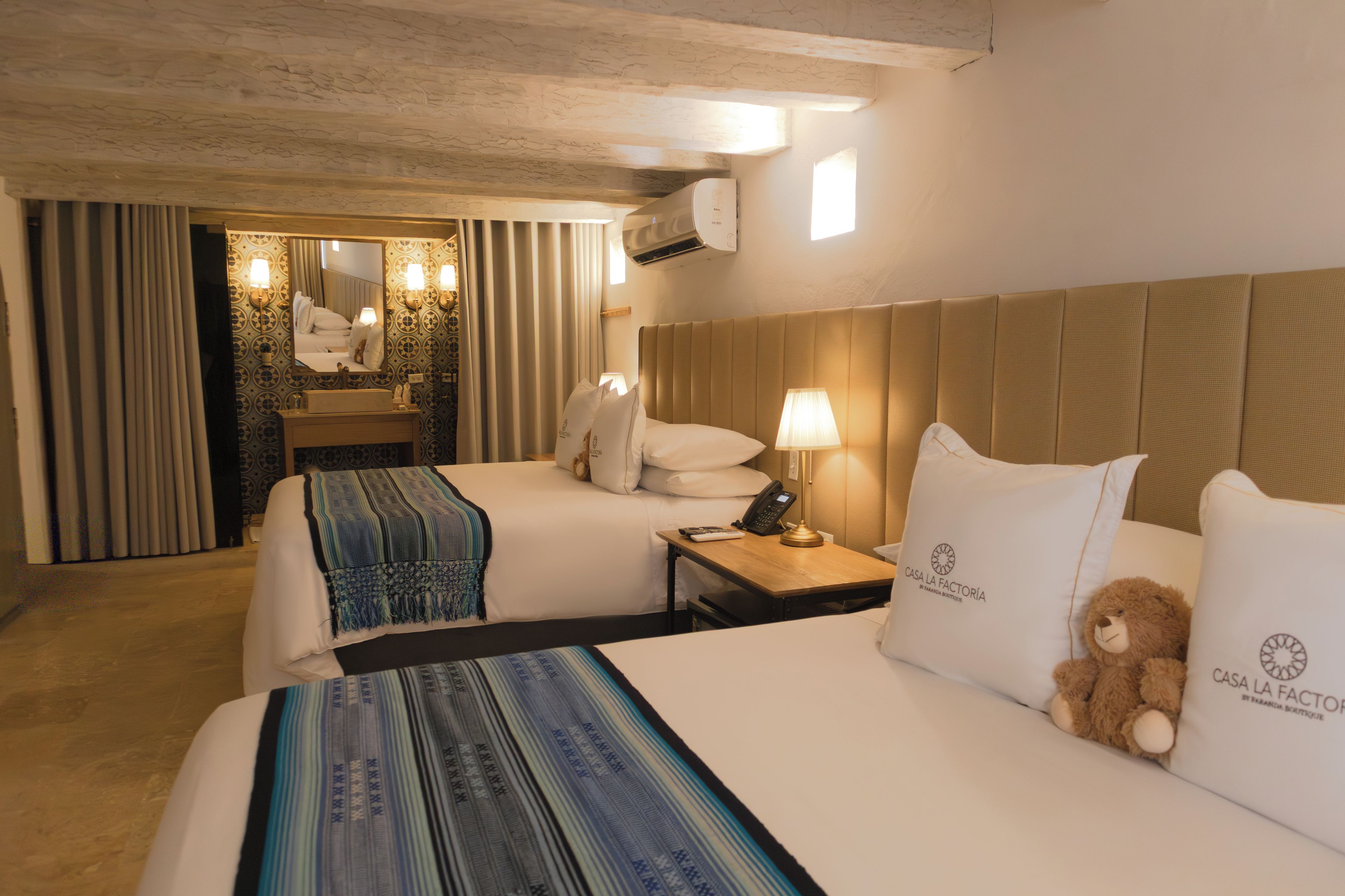 Una habitación de hotel con dos camas, un baño y vista de la habitación.