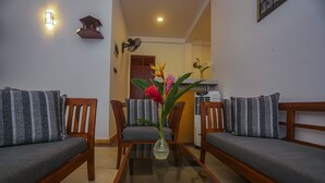 A living room with two sofas, a glass coffee table, and a vase with flowers. - Saku Residence (Unawatuna)
