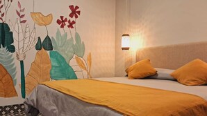 A hotel room with a bed, two pillows, a wall-mounted light, and a decorative wall with leaf patterns. - Hotel Refugio del Inca (Salta)