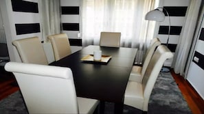 A conference room with a dark wooden table, white chairs, and a lamp. - Acropolis detached house (Athens)