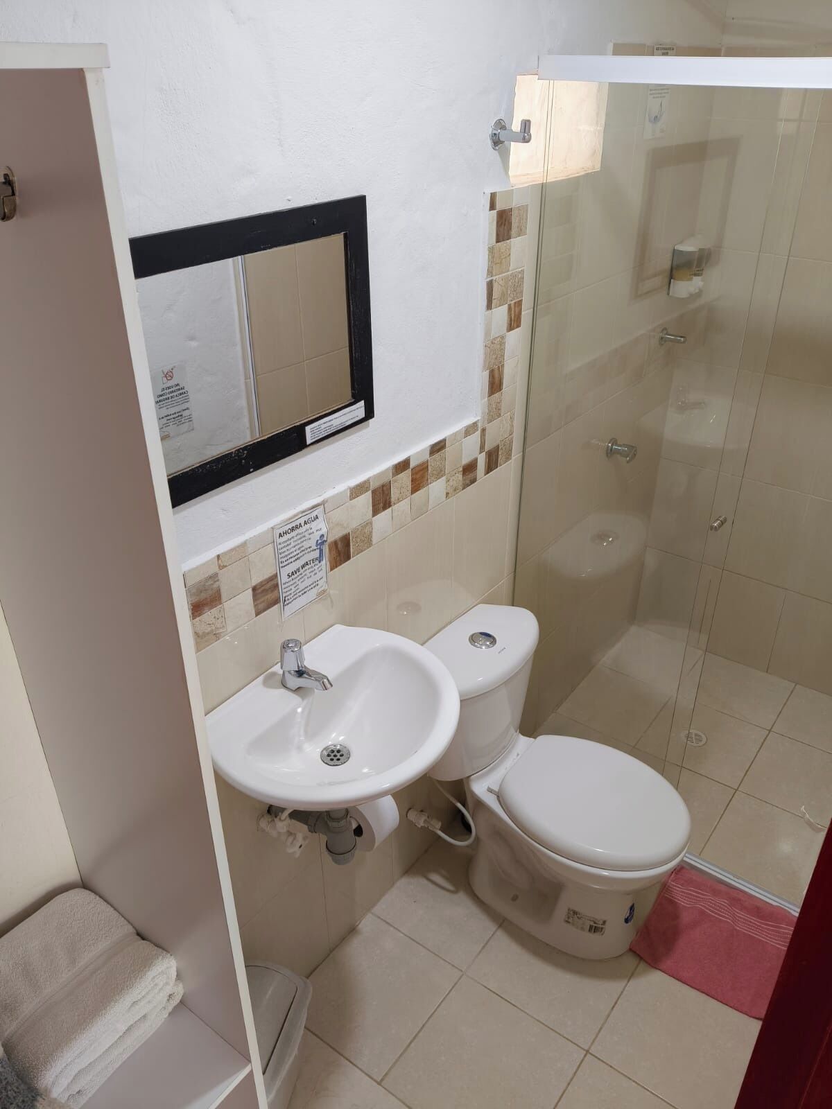 Un baño con inodoro, lavamanos y ducha.