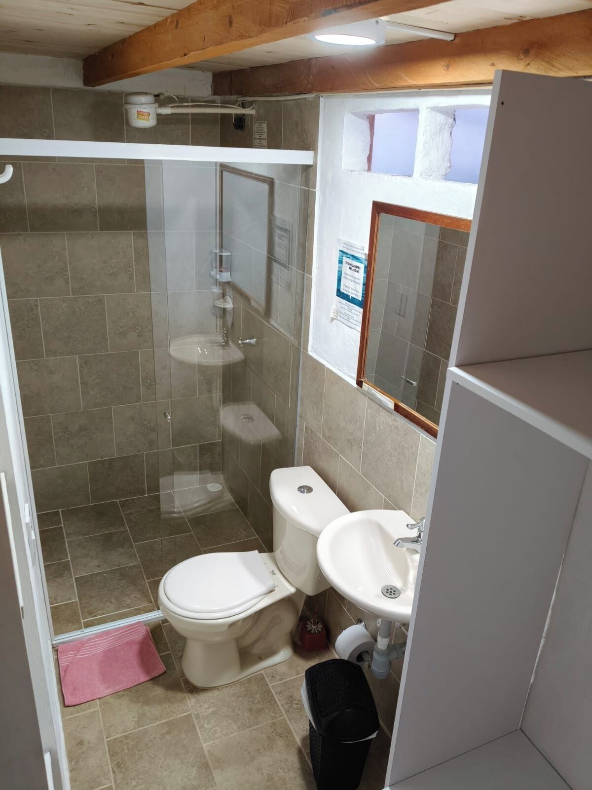 Ein kleines Badezimmer mit Dusche, Toilette und Waschbecken.