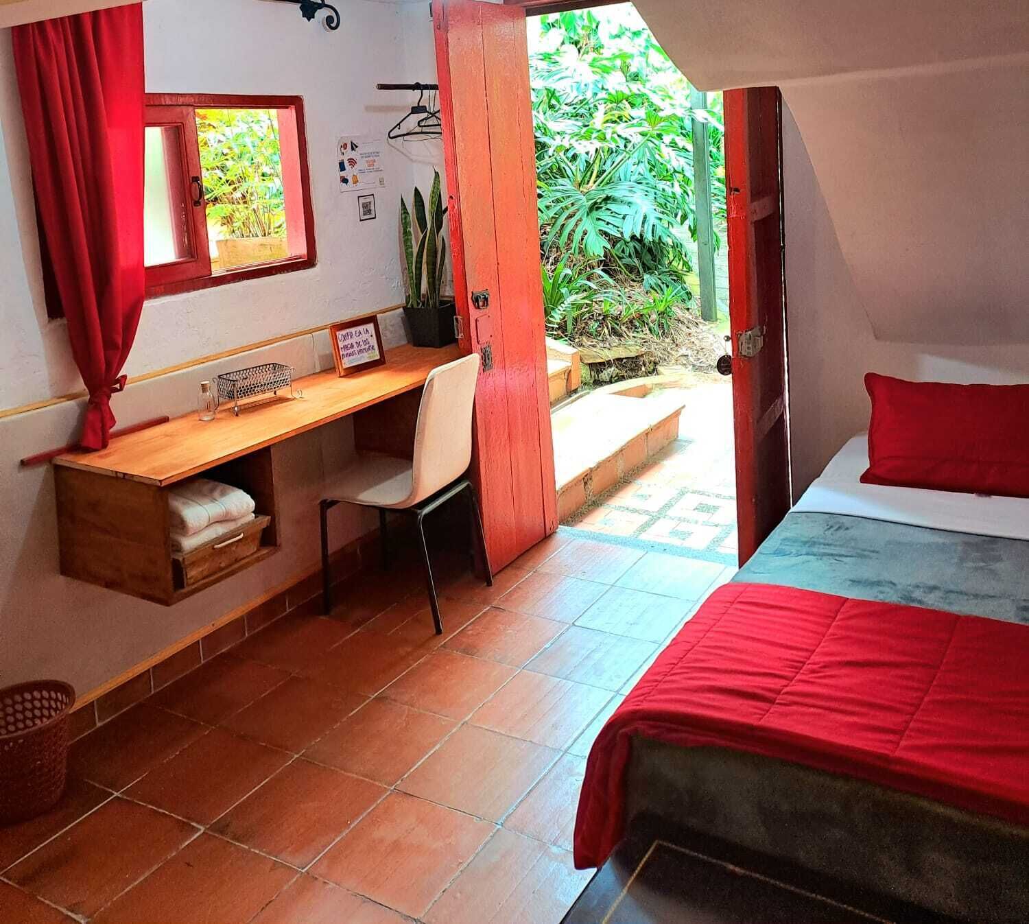 A bedroom with a bed, a desk, and a chair.