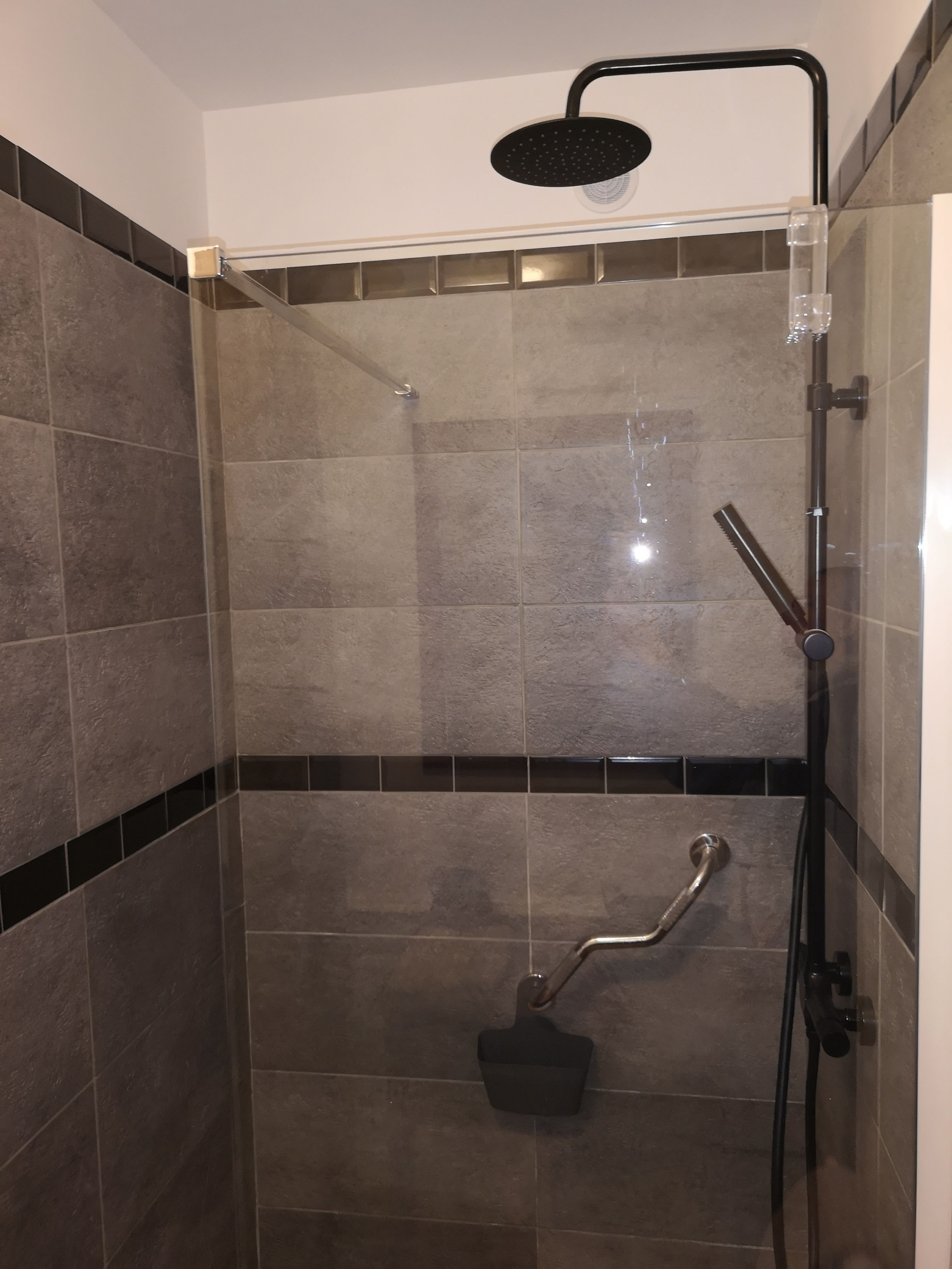 Un espace douche équipé d’un pommeau de douche à main, d’un autre pommeau de douche à main et d’un troisième pommeau de douche à main.