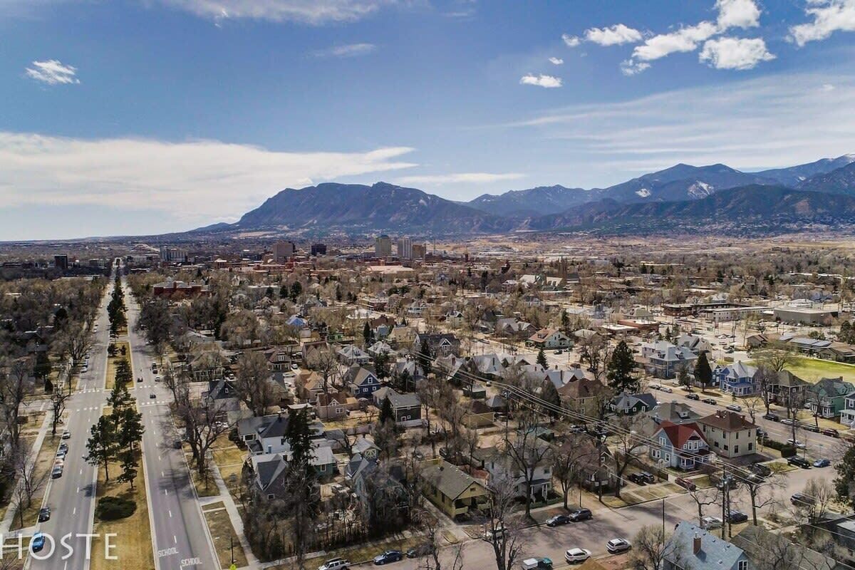 A town with a main road, residential areas, and mountains in the background.