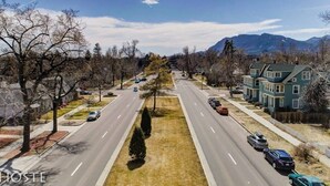 Una calle residencial con casas a un lado y una montaña al fondo.