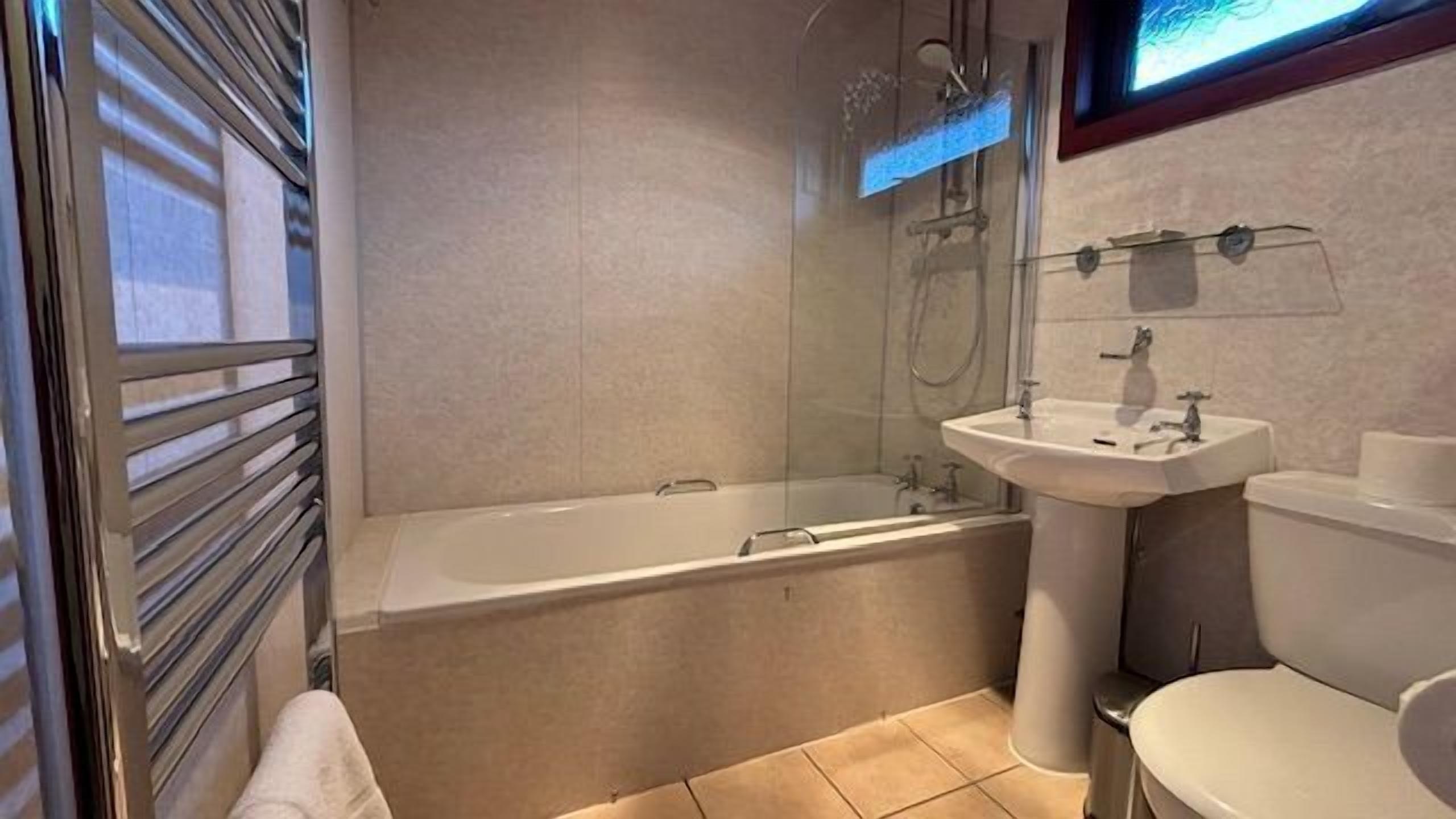 A modern bathroom with a bathtub, a sink, and a toilet.