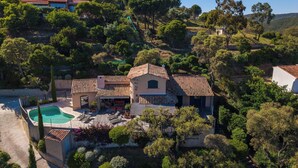 Une villa de style méditerranéen dotée d’une piscine, d’un jardin aménagé en terrasses et offrant une vue sur les collines.
