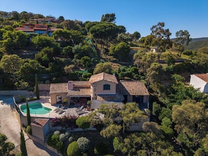 A Mediterranean-style villa with a swimming pool, terraced garden, and hillside views.