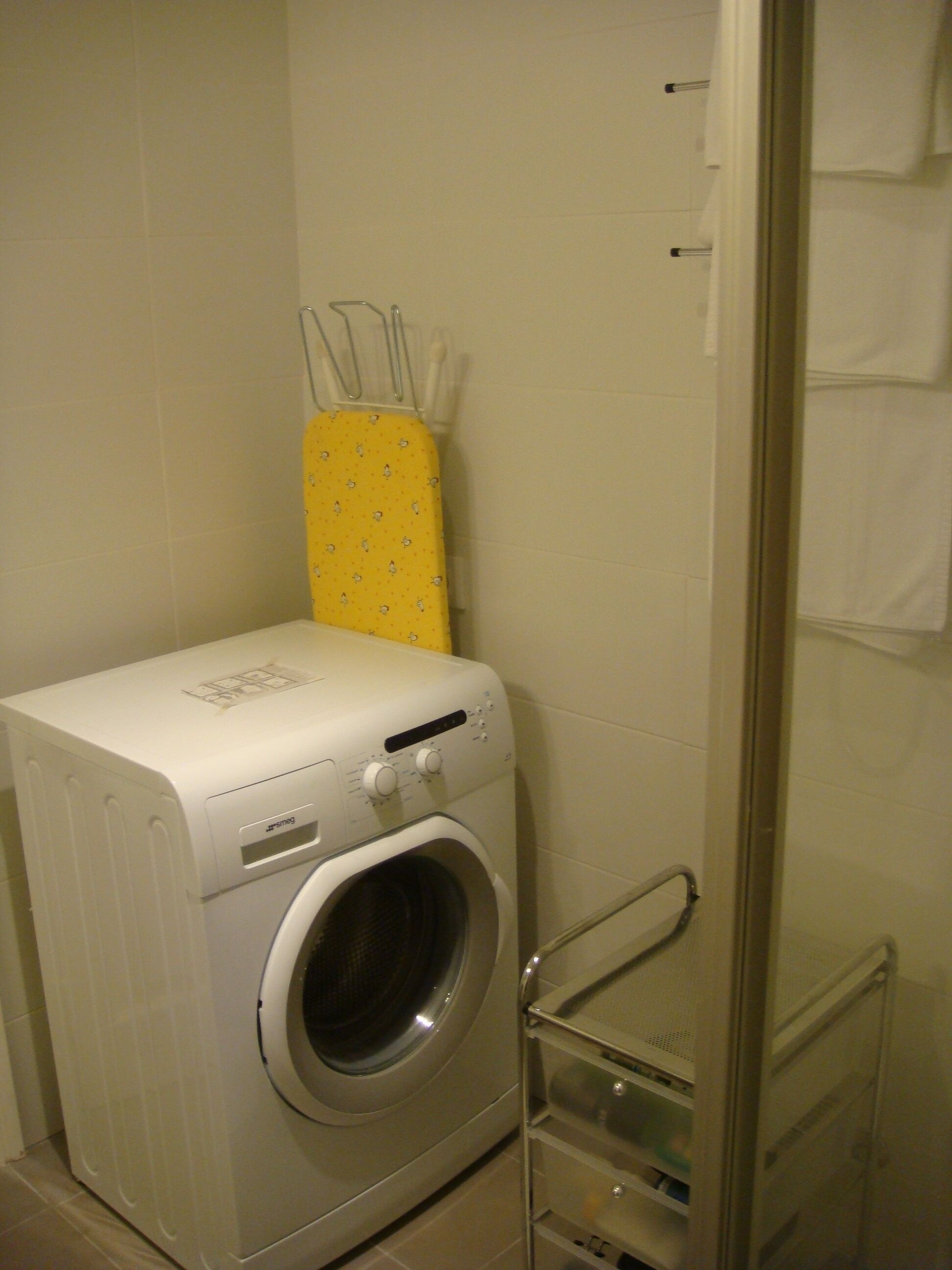 Een moderne, kleine badkamer met een ingebouwde wasmachine en toilet.