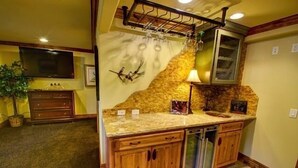 A kitchen with wooden cabinets, a granite countertop, a built-in oven, and a wine rack.