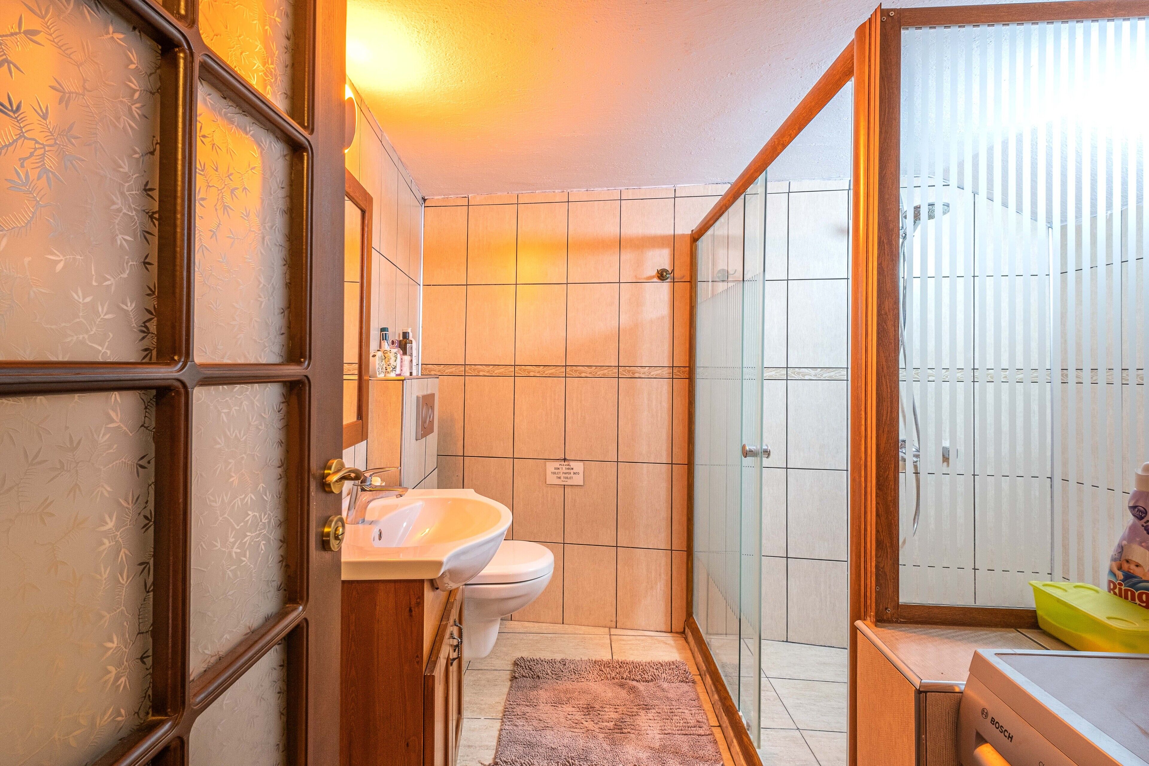 Une salle de bain comprenant des toilettes, un lavabo et un espace douche.