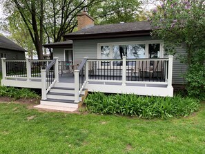 A house with a front porch, a staircase, and a small deck area.