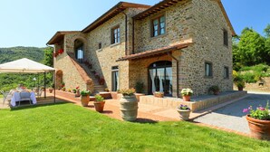 A stone building with a patio area, outdoor seating, and potted plants. - Private Villa with WIFI, private pool, TV, balcony, pets allowed, panoramic view, close to Cortona (Castiglion Fiorentino)