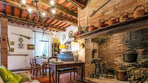 A rustic kitchen with a brick fireplace, wooden beams, and various kitchen utensils. - Wonderful private villa for 9 guests with private pool, WIFI, TV, patio and pets allowed (Montopoli In Val D'arno)