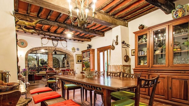 A dining area with a large wooden table, red cushioned benches, and a chandelier. - Wonderful private villa for 9 guests with private pool, WIFI, TV, patio and pets allowed (Montopoli In Val D'arno)