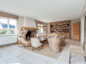 Een gezellige woonkamer met een open haard, een grote boekenkast en comfortabele zithoek.