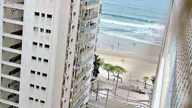 Un edificio alto con varios balcones que dan a una playa.