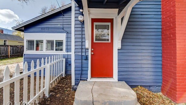 A house with a red door, a white picket fence, and a blue exterior. - Downtown Cottage with Netflix TV near Old Colorado (Colorado Springs)