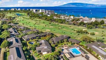 A residential area with houses, a golf course, and a swimming pool.