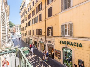 A street view with a pharmacy named 'FARMACIA' on the right. - Lovely apartment for 7 people with A/C, WIFI, TV and balcony (Rome)