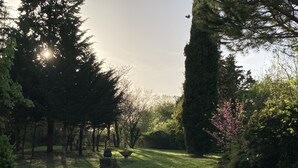 A garden with a stone fountain, trees, and a clear sky. - Mansion of an old farm, cottage in France, quiet and romantic stay in the Gers (Gavarret-Sur-Aulouste)