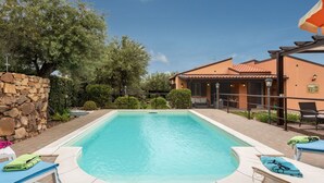 A swimming pool with lounge chairs, a stone wall, and a house with a tiled roof. - Wonderful private villa for 6 people with WIFI, A/C, private pool, TV and patio (Cefalù)