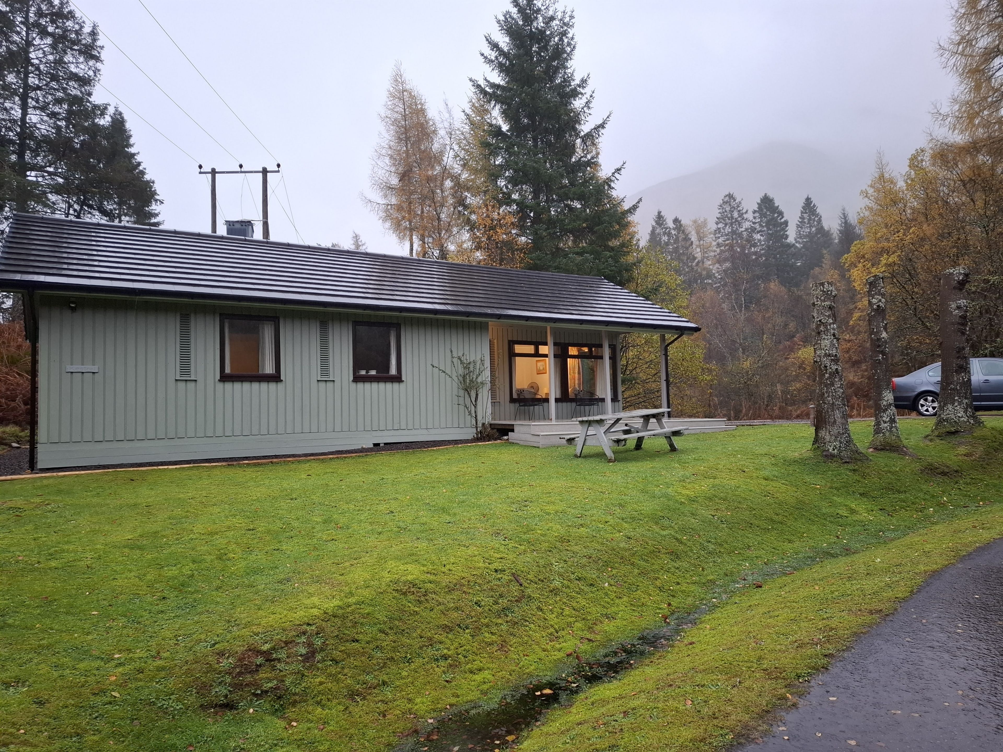A single-story building with a covered porch and a small outdoor seating area.