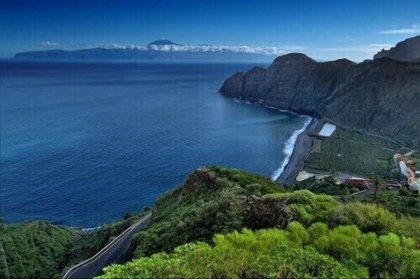 A coastal landscape with a road, cliffs, and a body of water. - Casa Rural El Serrillal 1, Hermigua, La Gomera (Hermigua)