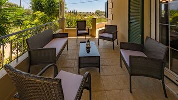 A balcony with wicker furniture, a table, and a lantern.