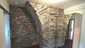 A hallway with a stone wall and a wooden floor. - Modern 5-star luxury in a historic setting (Boppard)