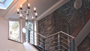 A dining area with a chandelier, a staircase, and a view of the outdoors. - Modern 5-star luxury in a historic setting (Boppard)