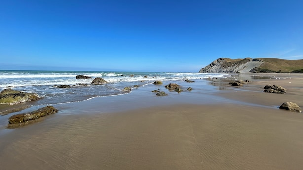 A beach with rocks and a clear sky. - 'Time Out'  Beach Front getaway with amazing sea views (Whangaehu Beach)