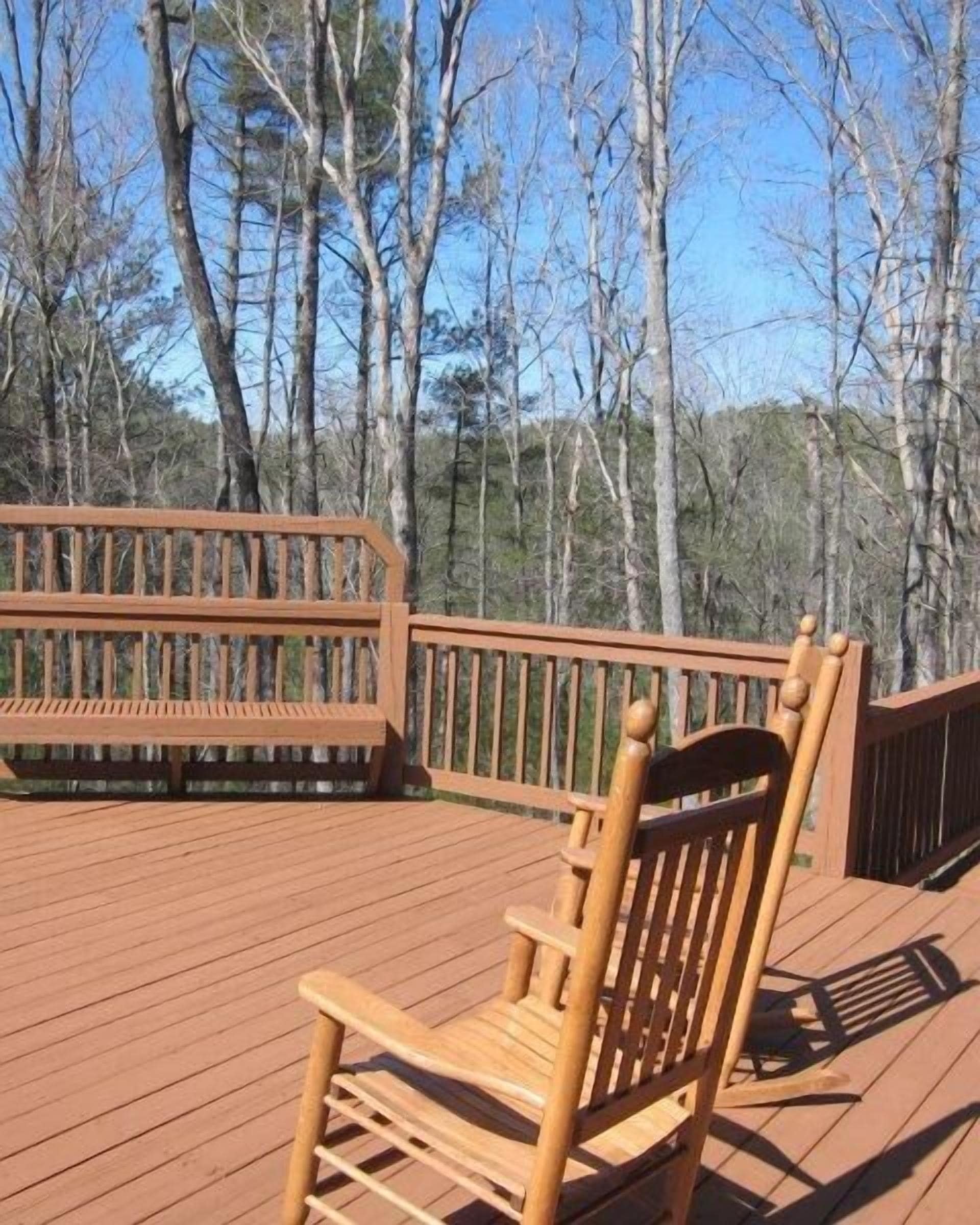 A wooden deck with a single wooden chair and a wooden bench.