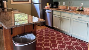 A kitchen with a granite countertop, stainless steel appliances, white cabinets, a red patterned rug, and a ceiling fan. - Stan's Lake Hamilton II, MainChannel, Kayaks, Fire Pit, Swim/Boat Dock, Pontoon (Hot Springs)