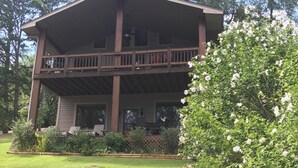 A two-story house with a balcony, surrounded by a well-maintained lawn and a stone pathway leading to the entrance. - Stan's Lake Hamilton II, MainChannel, Kayaks, Fire Pit, Swim/Boat Dock, Pontoon (Hot Springs)