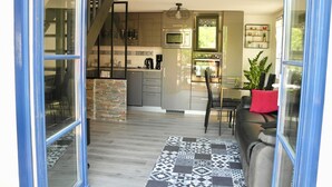 A modern kitchen with a microwave, stove, and coffee maker. There is a staircase leading to an upper level. - House for 4, close to the beach, shared pool (Saint-Hilaire-de-Riez)