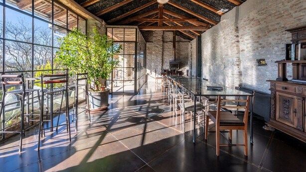 A spacious room with a high ceiling, large windows, and a rustic brick wall. - Stunning private villa with WIFI, private pool, TV, terrace, pets allowed and panoramic view (Trezzo Tinella)