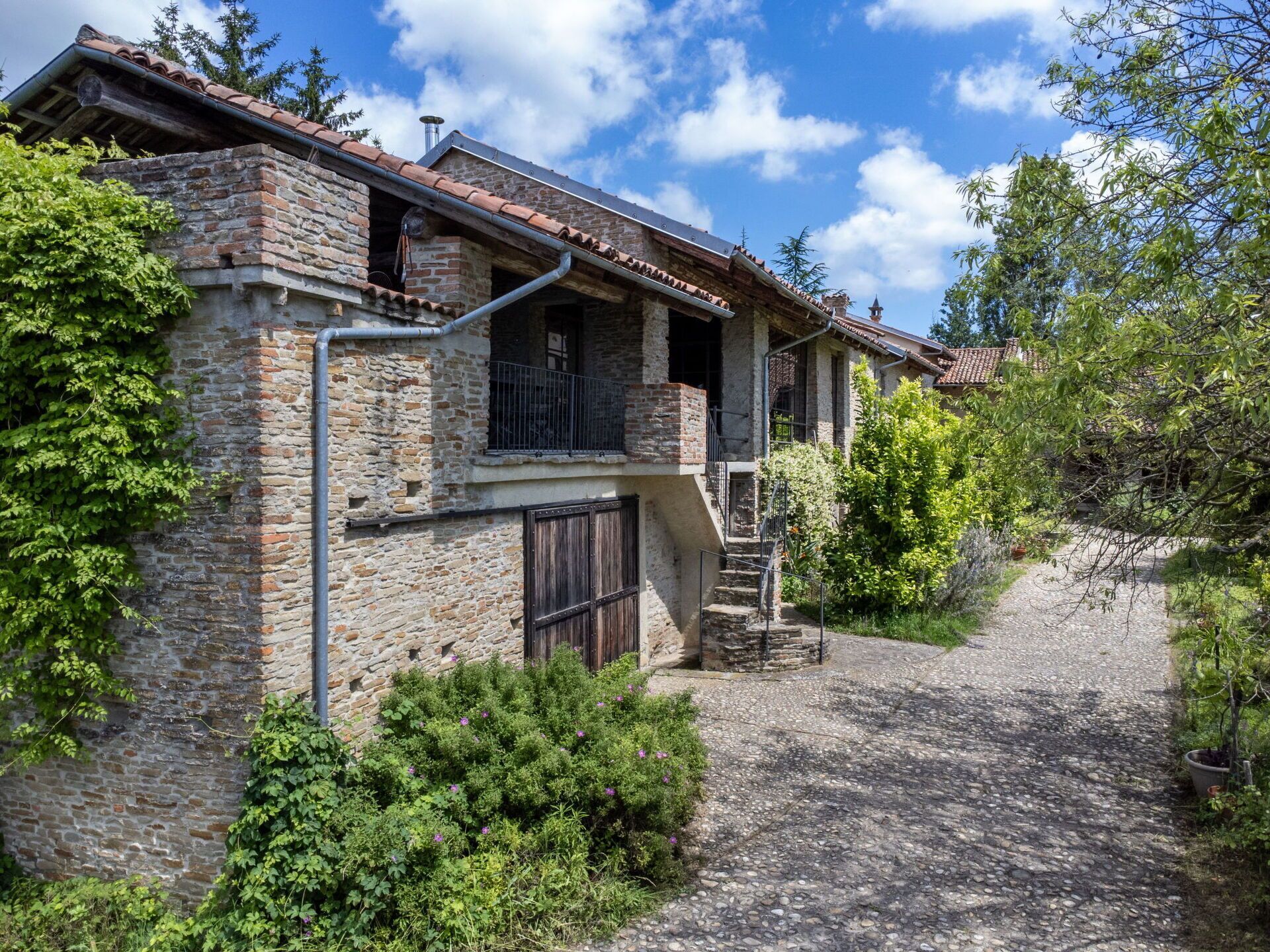 A rustic stone house with a stone staircase leading to a wooden door.