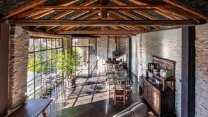 A spacious room with a high ceiling, exposed wooden beams, a large window, a fireplace, and a seating area with a sofa and chairs. - Stunning private villa with WIFI, private pool, TV, terrace, pets allowed and panoramic view (Trezzo Tinella)