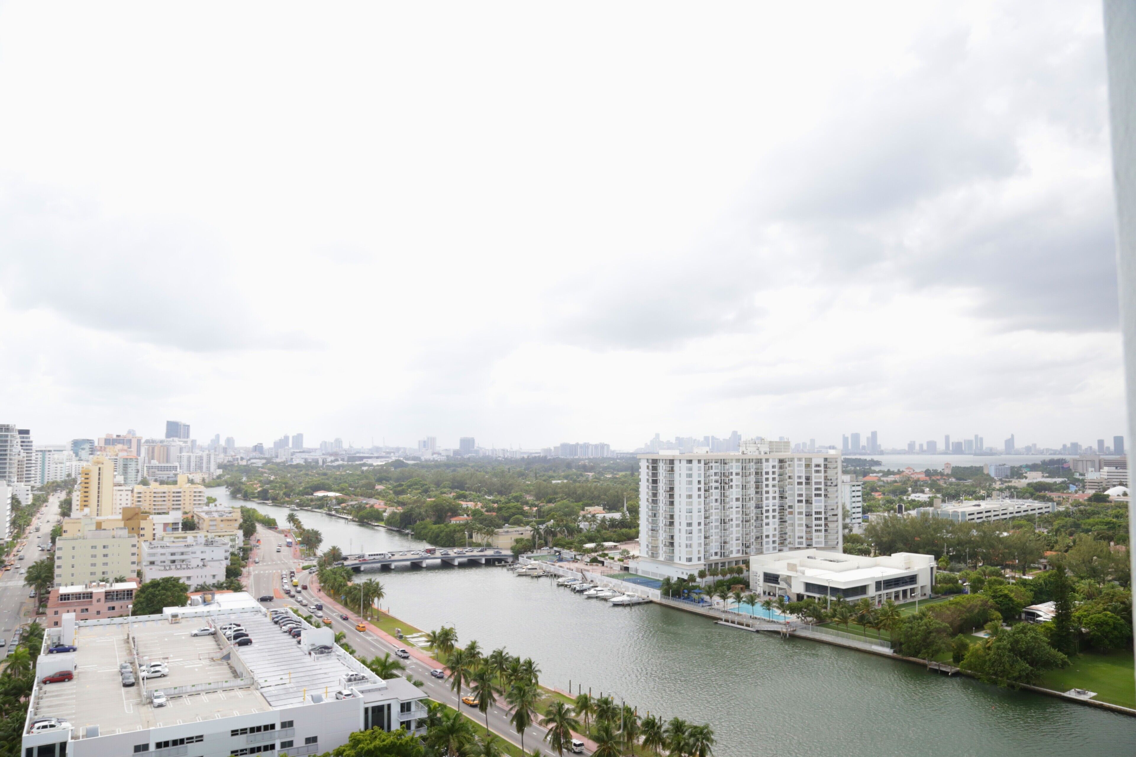 Un hotel moderno con vistas a un puerto deportivo con barcos, un río y el horizonte de la ciudad.