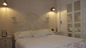 A neatly made bed with floral bedding, a white headboard, bedside tables with lamps, and a white wardrobe with glass doors. - With garden very close to the beach IN COSTABELLA BETWEEN KAPAS AND MONTEROS (WIFI) (Marbella)