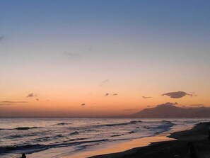 A beach scene with waves and a clear sky.