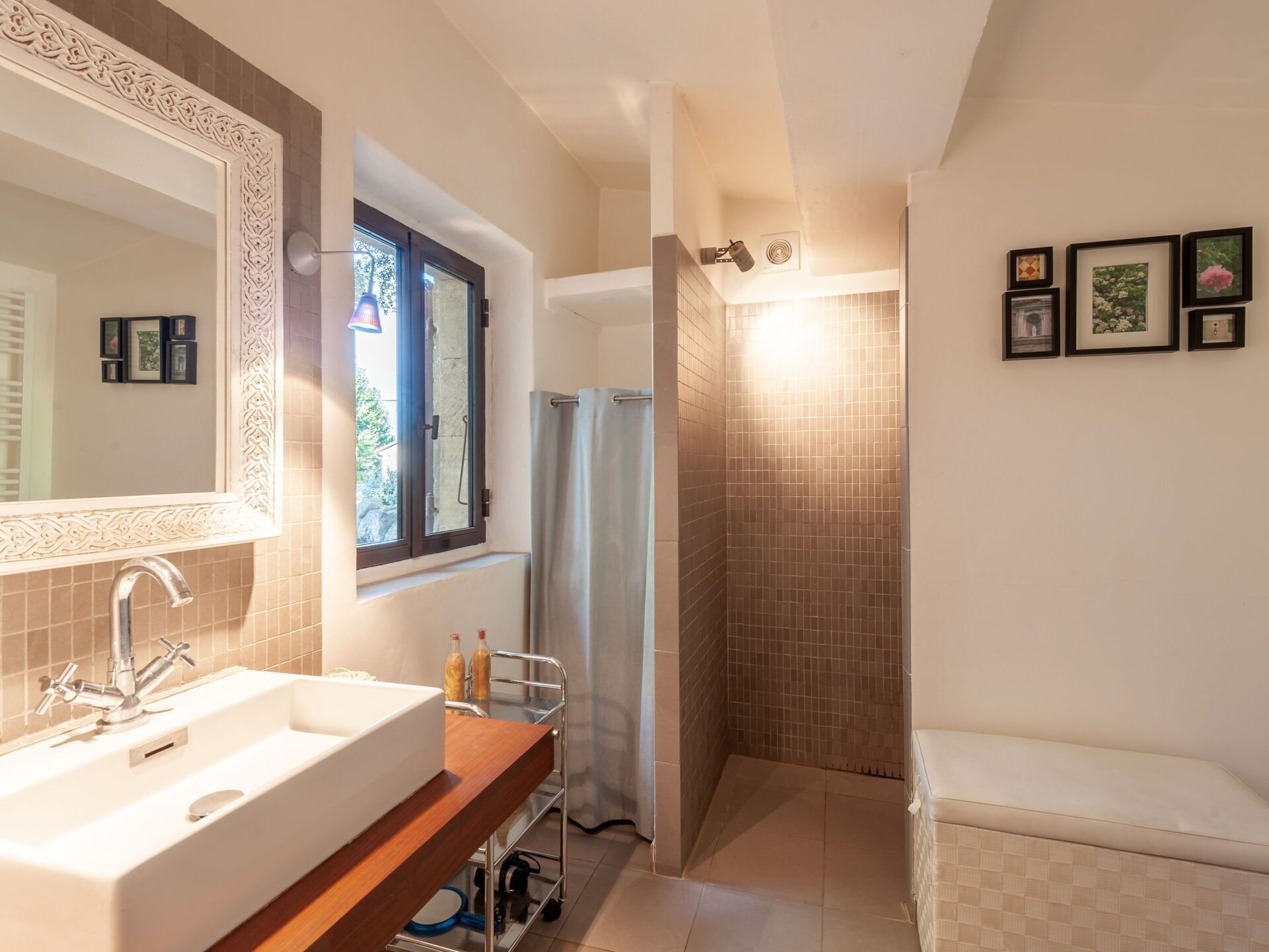 Un baño con un espejo grande, un lavabo, una ducha y un inodoro.
