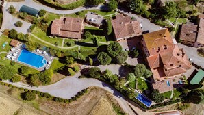 An aerial view of a residential area with multiple houses, a swimming pool, and solar panels. - Cosy apartment in villa for 4 guests with A/C, WIFI, pool, TV and patio (Città Della Pieve)