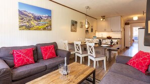 Un salon moderne avec un canapé gris, des coussins rouges et une table basse en bois.