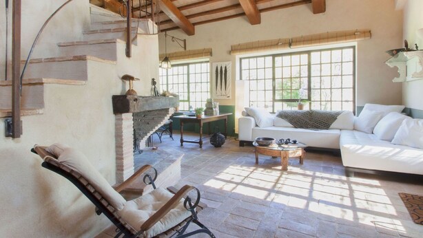 Un salón amplio con chimenea, un sofá, una mesa de comedor y una silla.