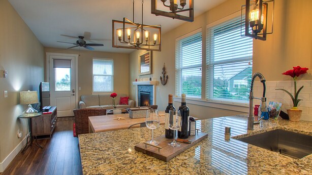 A kitchen with a granite countertop, a fireplace, and a dining area with a sofa and table.