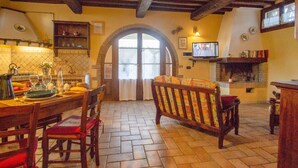 A cozy kitchen with a wooden table, chairs, and a television. - Nice apartment in villa with pool, WIFI, TV, terrace and pets allowed, close to San Gimignano (Poggibonsi)