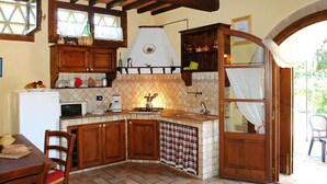 A rustic kitchen with wooden cabinets, a tiled backsplash, and a built-in stove. - Nice apartment in villa with pool, WIFI, TV, terrace and pets allowed, close to San Gimignano (Poggibonsi)